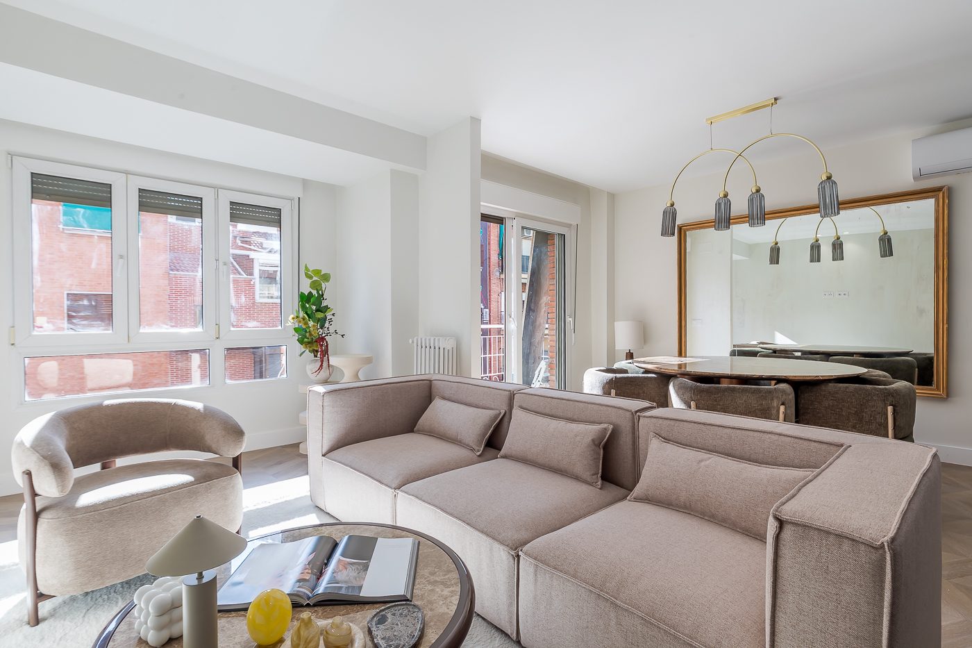 Salón luminoso con sofá modular y lámpara dorada de la vivienda en venta en Calle Marcenado 21, Chamartín